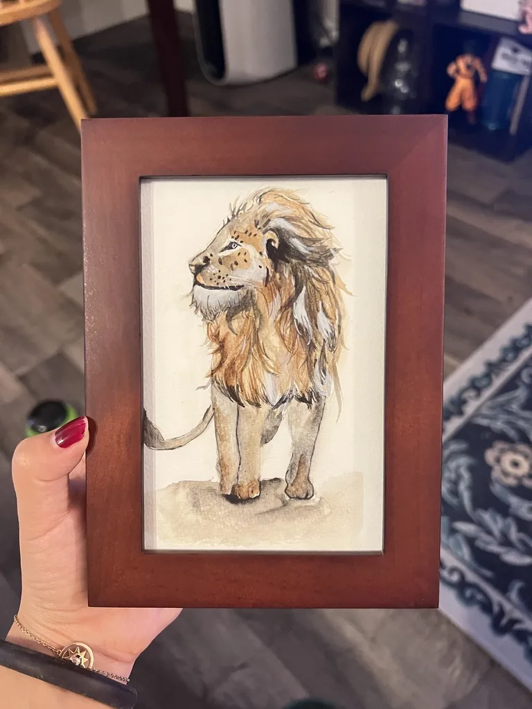 Watercolor of a lion with a flowing golden mane